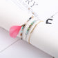 Lovra feather pendant bracelet displayed alongside matching jewelry pieces