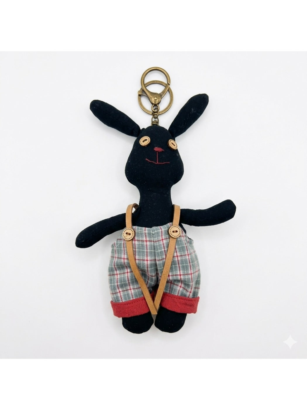 Fabric puppy keychain held in hand to show scale and detail