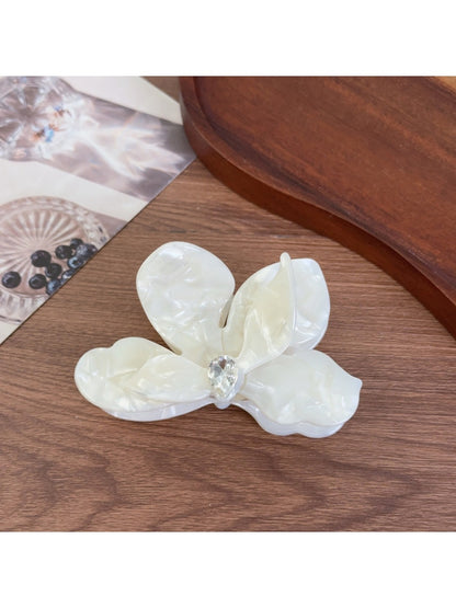 Beau acetate moth orchid claw clip resting on a wooden surface