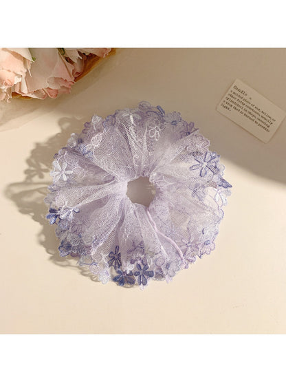 Flat lay of Gifty trendy floral ruched scrunchie alongside matching accessories