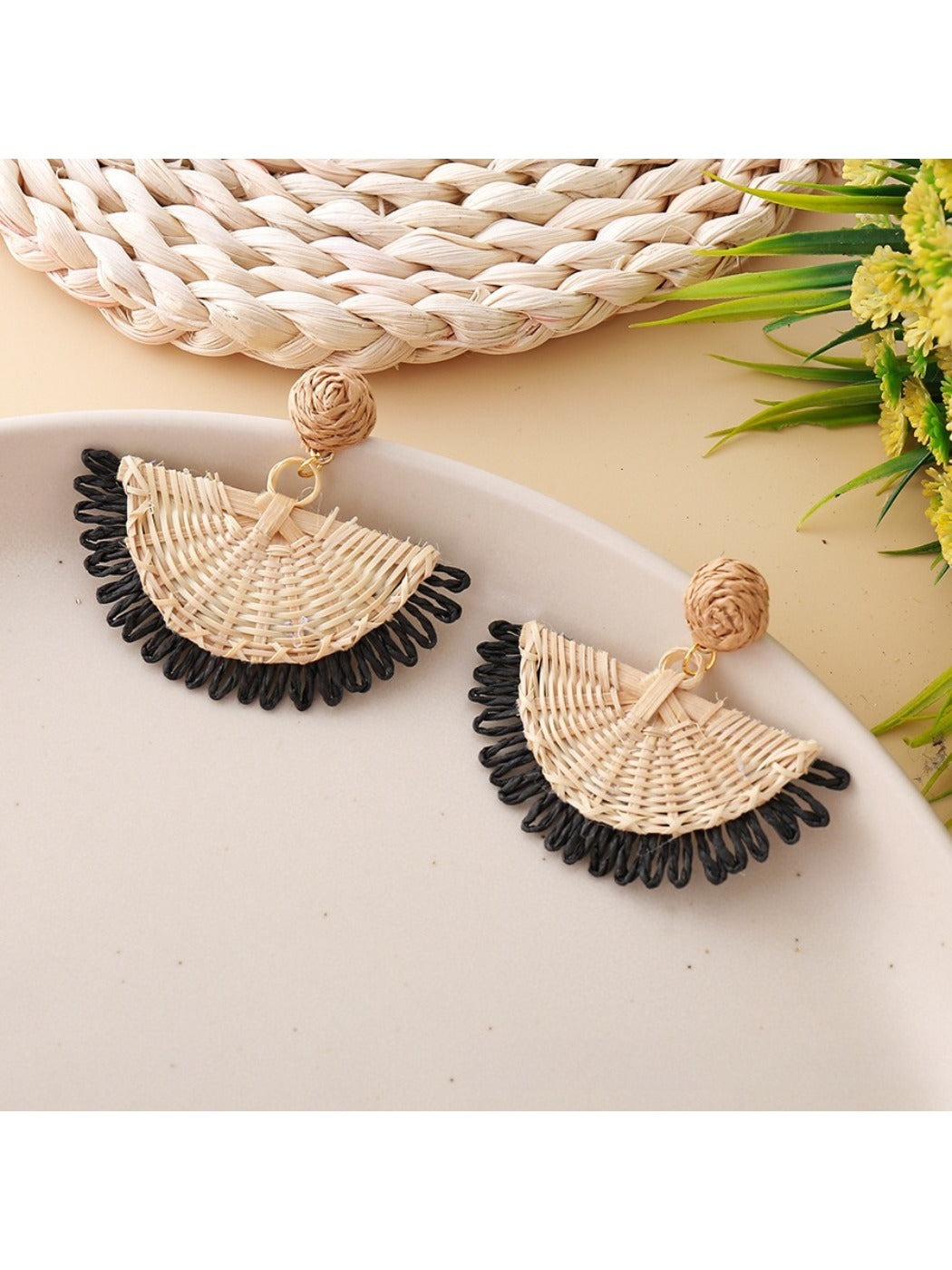 Close-up of earring hook and raffia fan detail on drop earrings