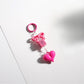 Keypus keychain displayed on a wooden surface showing pink bow and heart beads