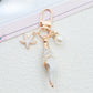 Gold conch keychain hanging from a leather bag strap
