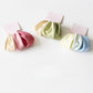 Multiple solid color hair ties stacked together displaying various muted tones
