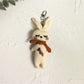 Silver vintage rabbit charm keychain with intricate design on a dark fabric background