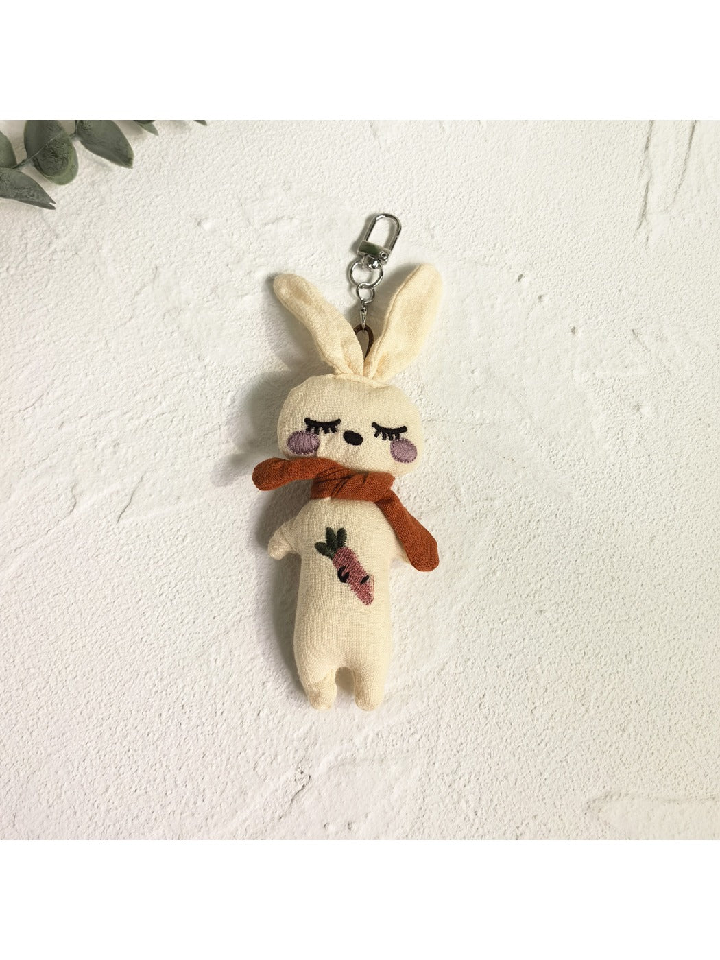 Silver vintage rabbit charm keychain with intricate design on a dark fabric background