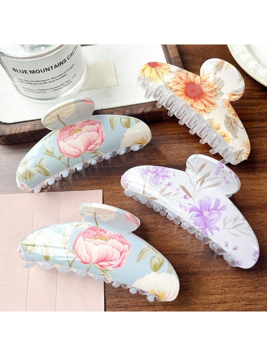 Beau hair clip showing multicolored floral design on a curved clip base