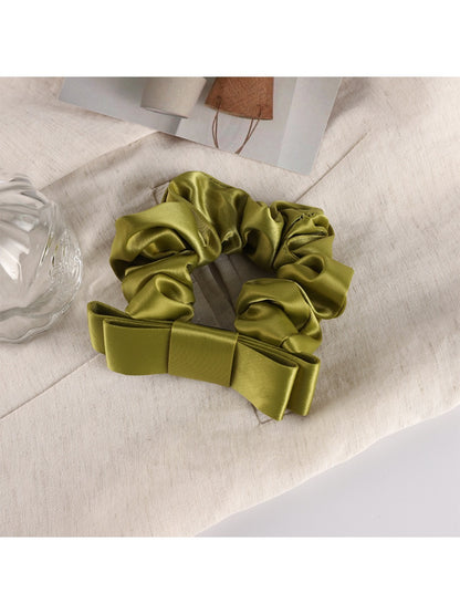 Romantic charm scrunchie styled with loose curls for a soft feminine look