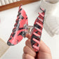 Beau hair claw clip held in hand displaying size and crow motif