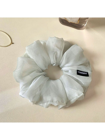 Grey scrunchie wrapped around a ponytail on a model with light hair
