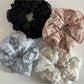 Close-up of Gifty Sweet Cutout Lace Scrunchie in white fabric with floral lace pattern