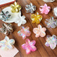 Beau stylish flower shaped claw clip in soft pink on white background