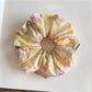Close-up of vibrant, multicolored scrunchie showing detailed brushstroke design