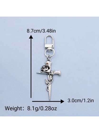 Rose cross keychain attached to a set of keys on a wooden surface