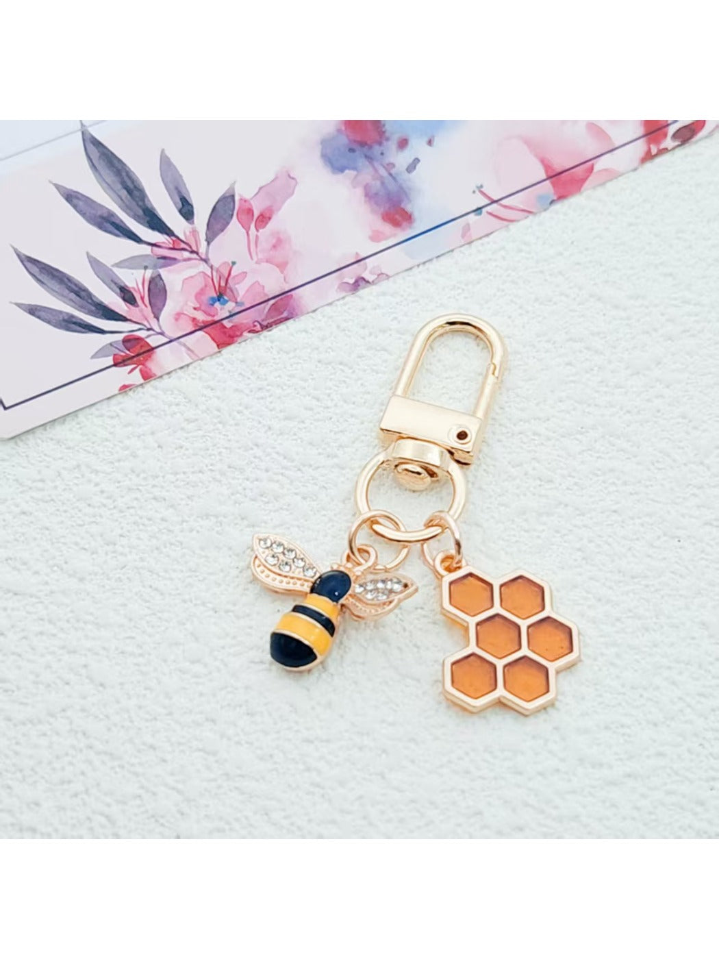 Bee and honeycomb keychain held in hand to show size and detail