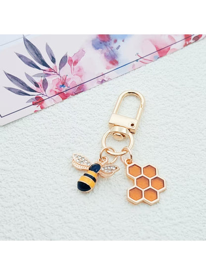 Bee and honeycomb keychain held in hand to show size and detail