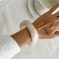 Lovra asymmetrical bangle bracelet paired with matching rings on hand