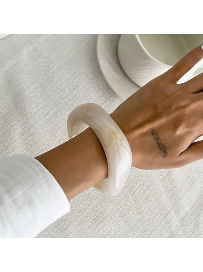 Lovra asymmetrical bangle bracelet paired with matching rings on hand