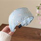Headband displayed on a wooden surface highlighting its soft fabric and floral design