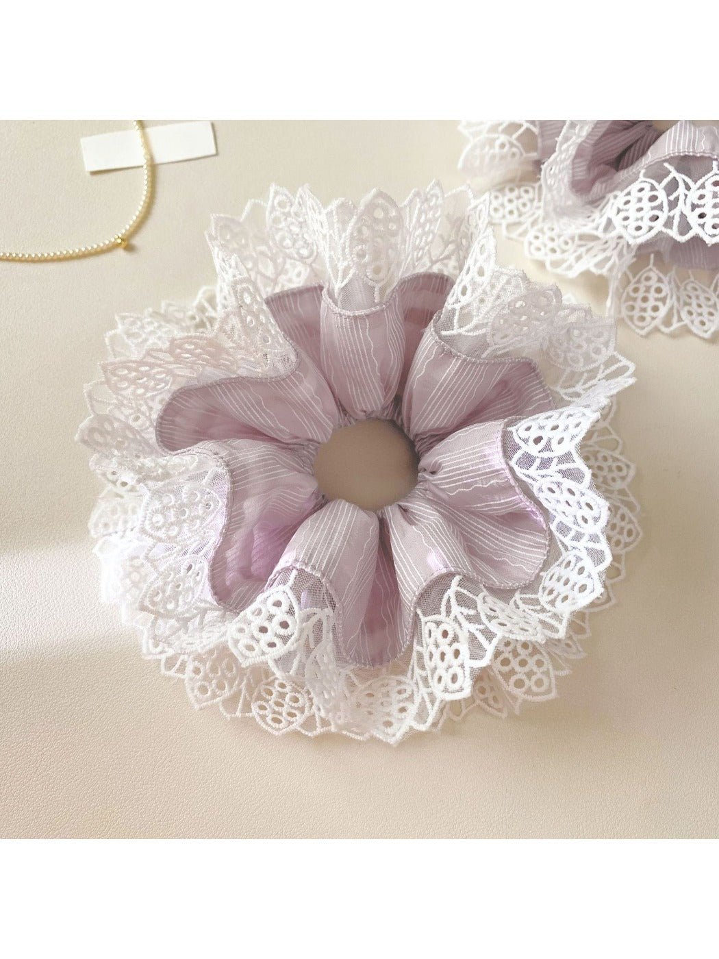 Gifty purple lace trim scrunchie styled on a model's wrist with casual outfit