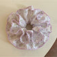 Purple scrunchie with floral print on a white background