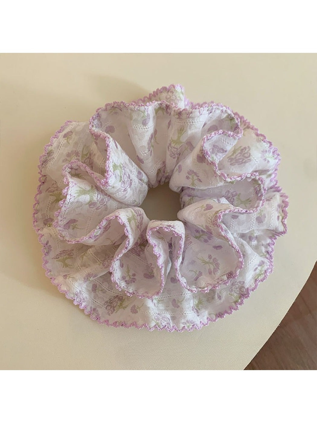 Purple scrunchie with floral print on a white background