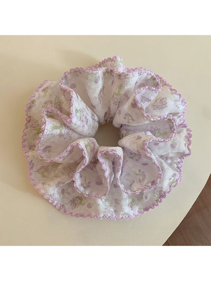 Purple scrunchie with floral print on a white background