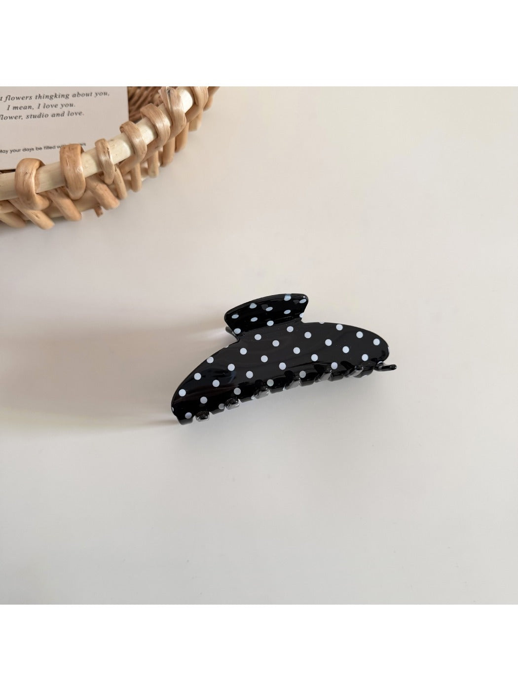 Side view of Beau polka dot hair clip displaying clip mechanism and curved shape