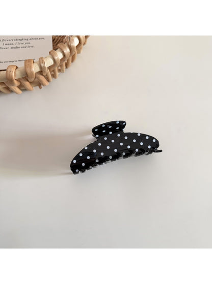 Side view of Beau polka dot hair clip displaying clip mechanism and curved shape