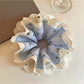 Gifty ruffled scrunchie with bow print displayed on a wooden surface