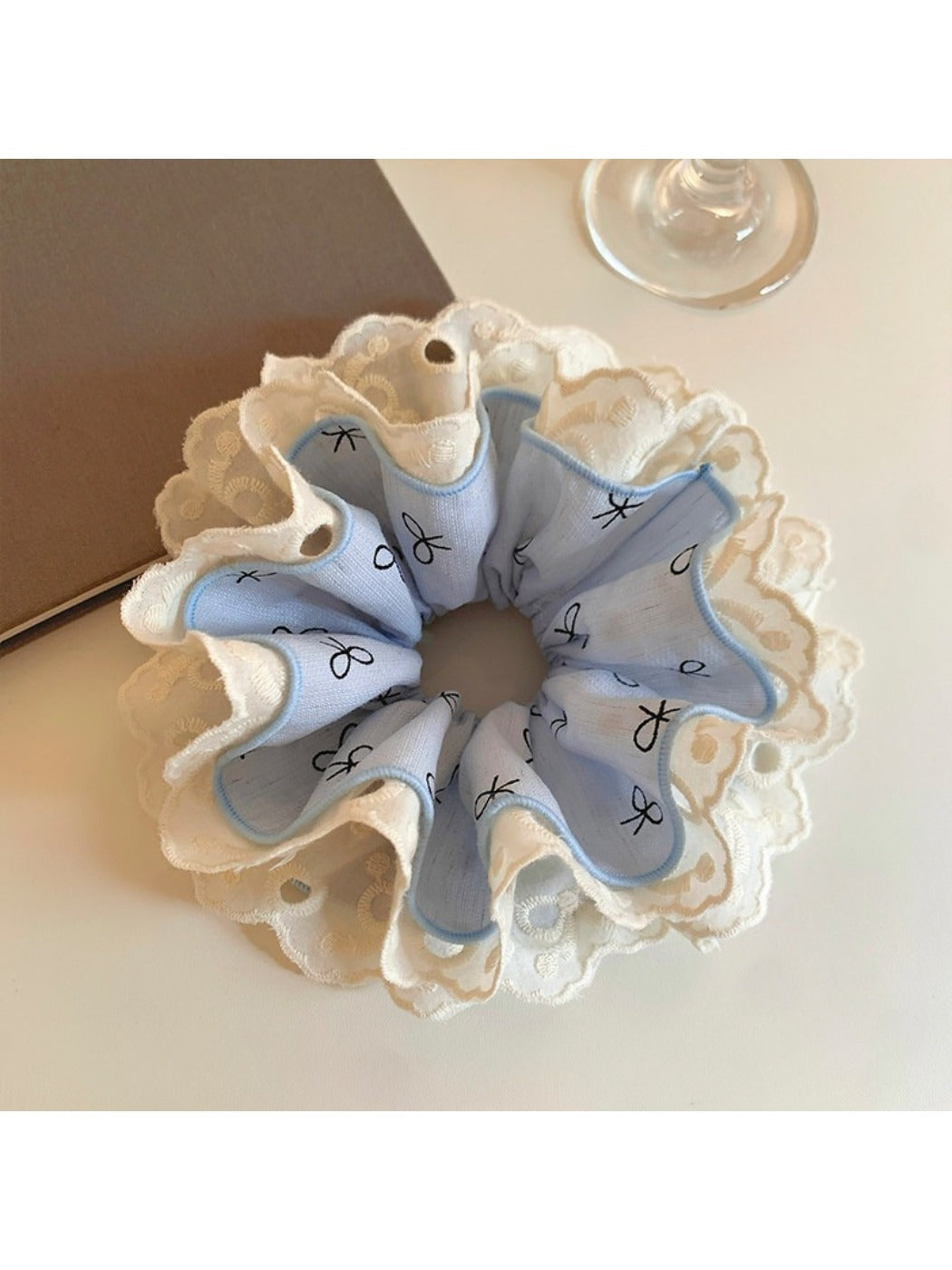 Gifty ruffled scrunchie with bow print displayed on a wooden surface