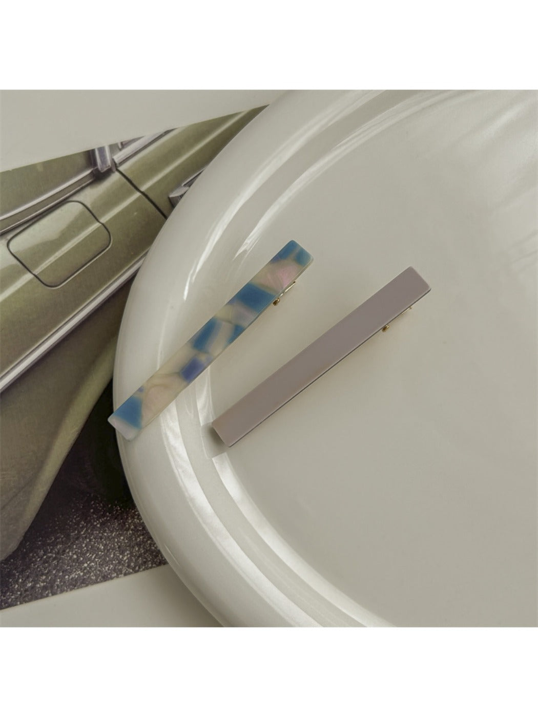 Beau hair clip positioned on fabric surface emphasizing smooth acetate texture