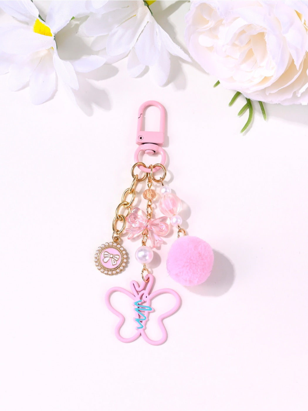 Pink heart keychain attached to a set of keys on a white background