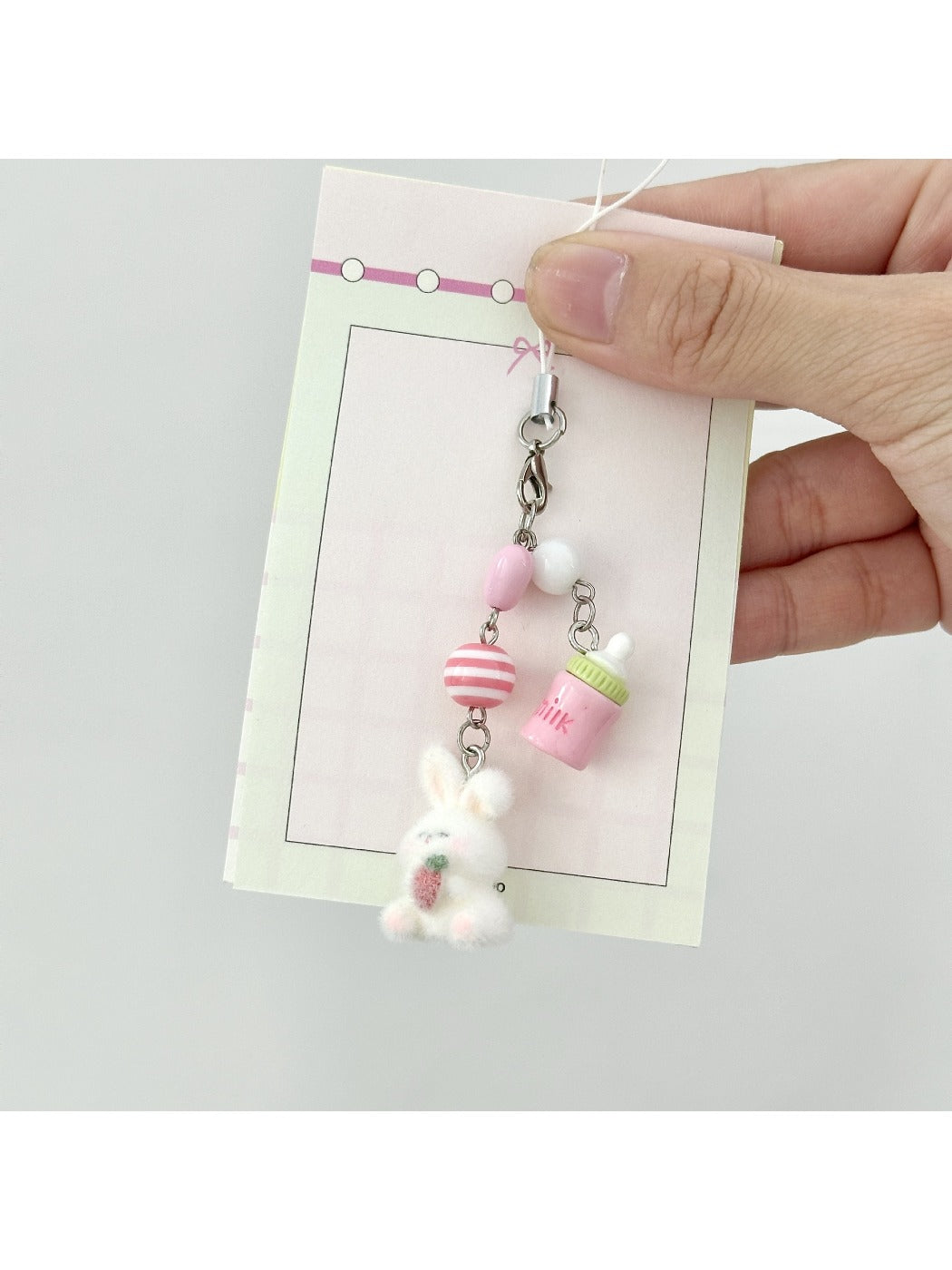Side view of a soft textured bunny keychain attached to a silver keyring