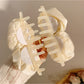 Beau hair claw clip displayed on a white background emphasizing its delicate rose decor