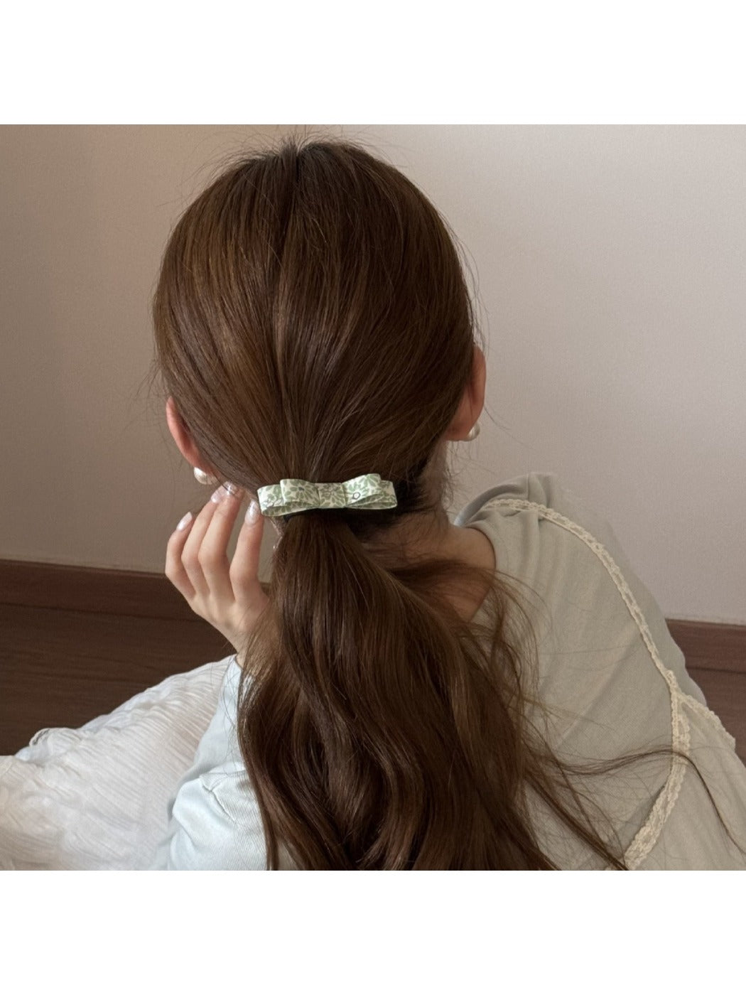 Side view of a pink bow hair tie showing the elastic band detail