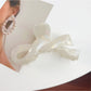 Beau hair claw clip in pastel pink with metal spring mechanism visible