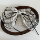 Beau floral bow hair clip styled in hair, showcasing its decorative floral design