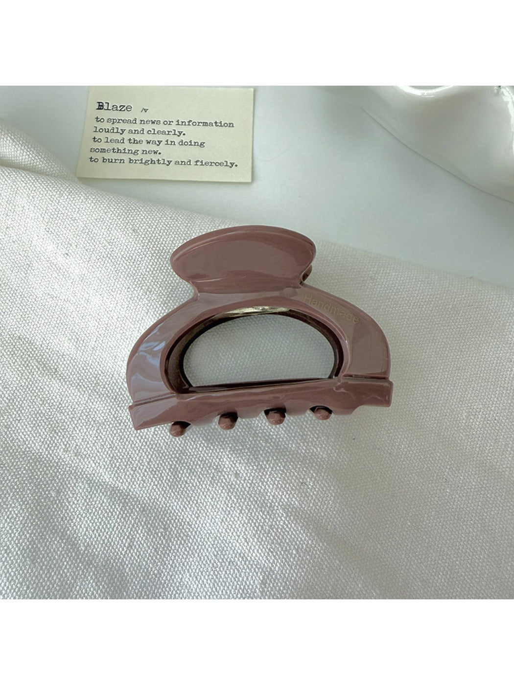 Beau claw clip placed on fabric to display texture and vintage openwork details