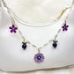 Daisy pendant bag charm hanging from a beige handbag strap