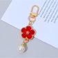 Keypus colorful flower charm keychain held in a hand showing size and detail