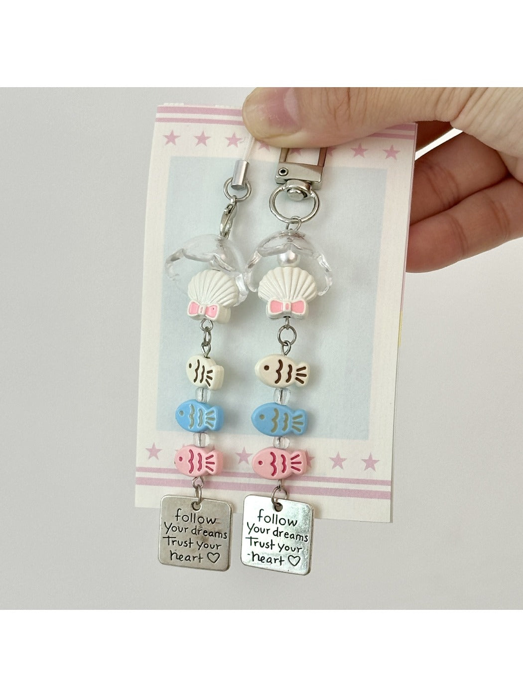Three fish-shaped keychains in pastel colors attached to a metal ring
