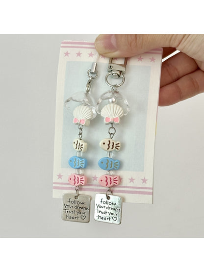 Three fish-shaped keychains in pastel colors attached to a metal ring