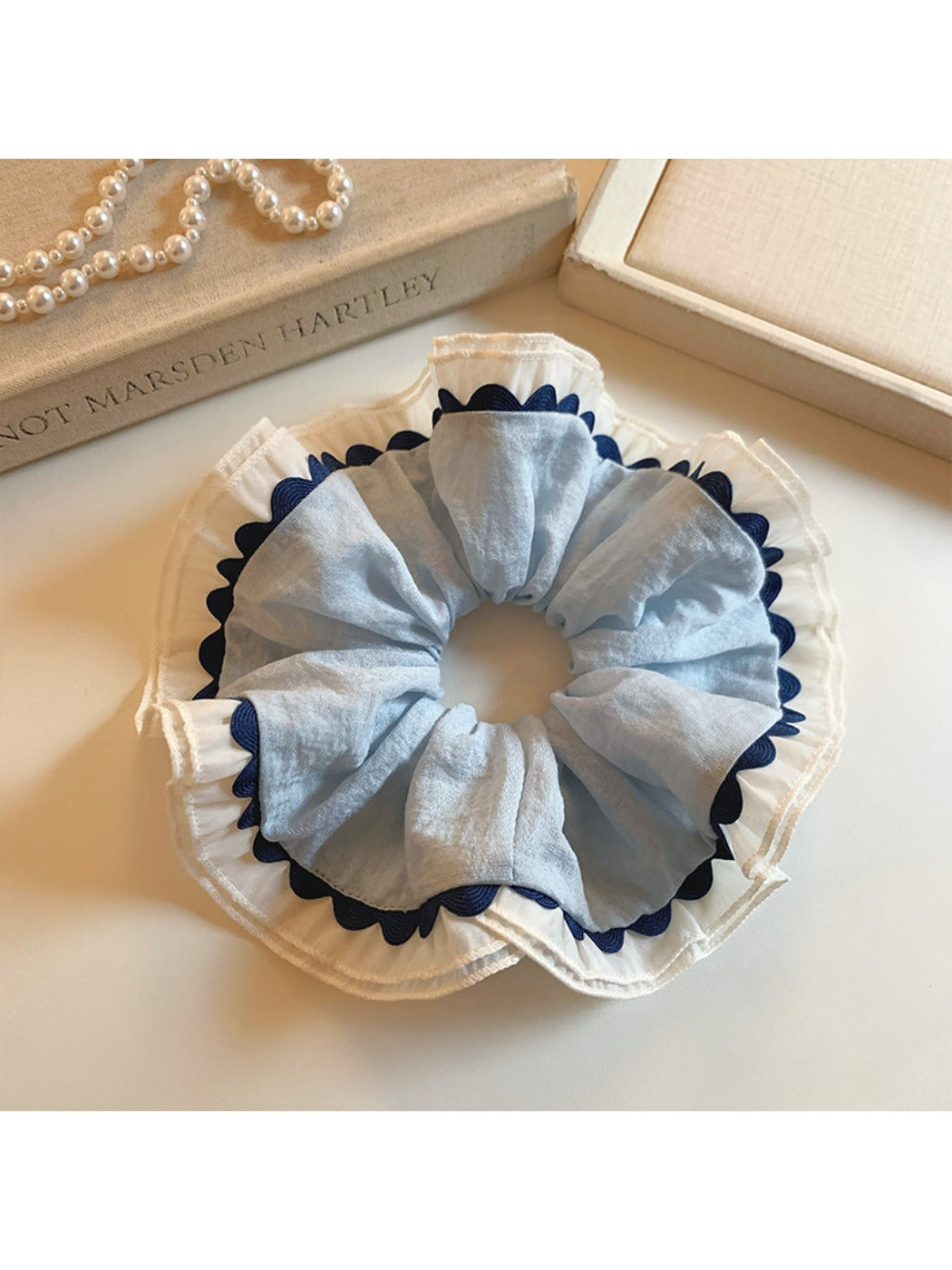 Gifty scrunchie worn on wrist, displaying elegant color block and ruched detail
