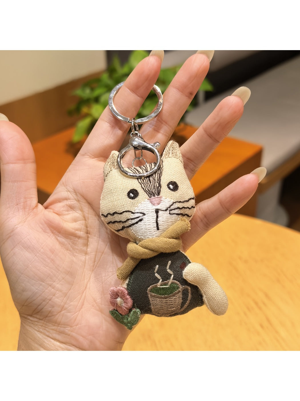 Vintage cat charm keychain next to a ruler showing compact size