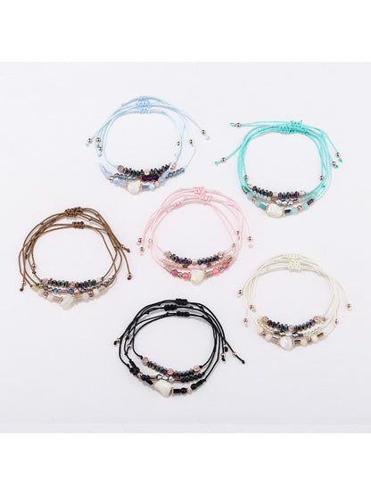 Close-up of Lovra beaded woven cord bracelet with multicolored beads on black cord