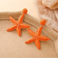Pair of starfish shaped drop earrings with polished silver finish