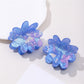 Close-up of blue flower hair clip showing petal texture and clip mechanism