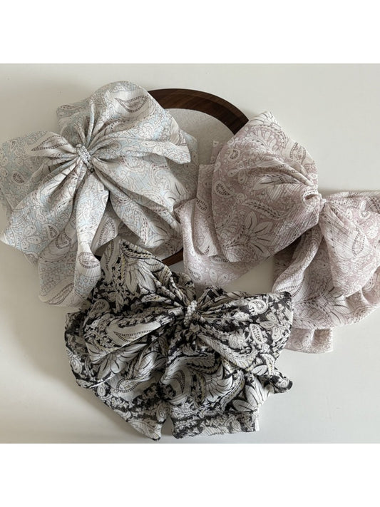 Beau chiffon bow shaped claw clip in soft pastel pink on white background