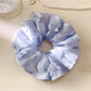 Gifty ruched scrunchie with floral accents styled on a wrist